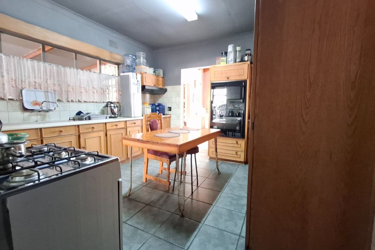 A dated kitchen featuring wooden cabinetry, tiled flooring, a gas stove, and a built-in oven, offering potential for a modern renovation.