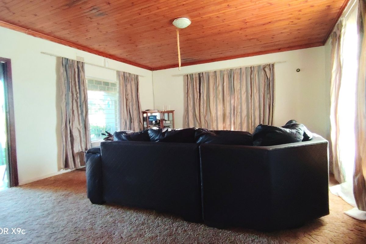 Living room featuring a timber tongue and groove ceiling and access to the exterior via a glass sliding door.