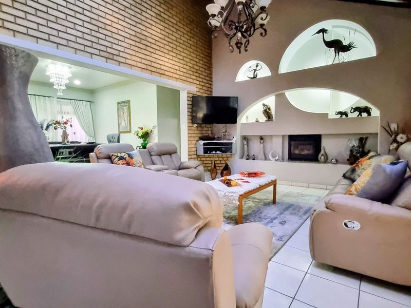 Spacious living room featuring an exposed brick wall, built-in fireplace, and unique arched wall niches, creating a warm and character-filled atmosphere.