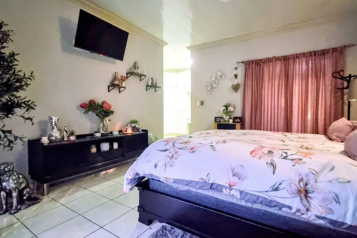 A bedroom featuring tiled flooring and coved ceiling details, providing a functional space with neutral wall finishes.