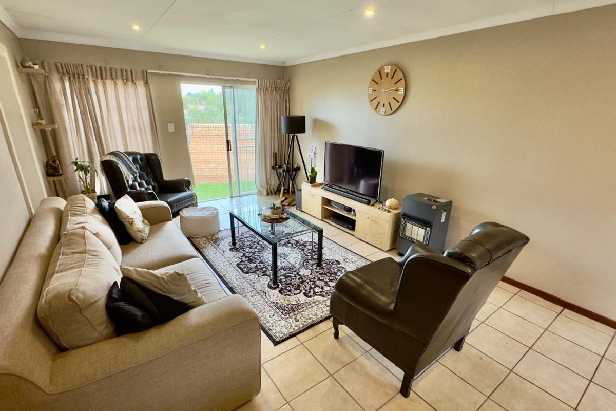 A comfortable living room featuring tiled flooring and sliding glass doors that provide access to the outdoor area.