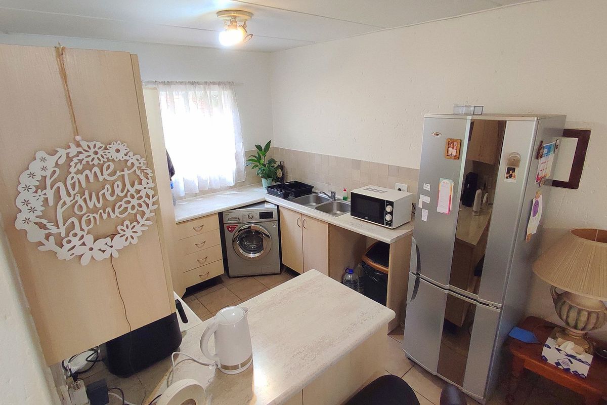 Compact kitchen featuring laminate countertops, built-in cabinetry, a double bowl sink, and an integrated washing machine.