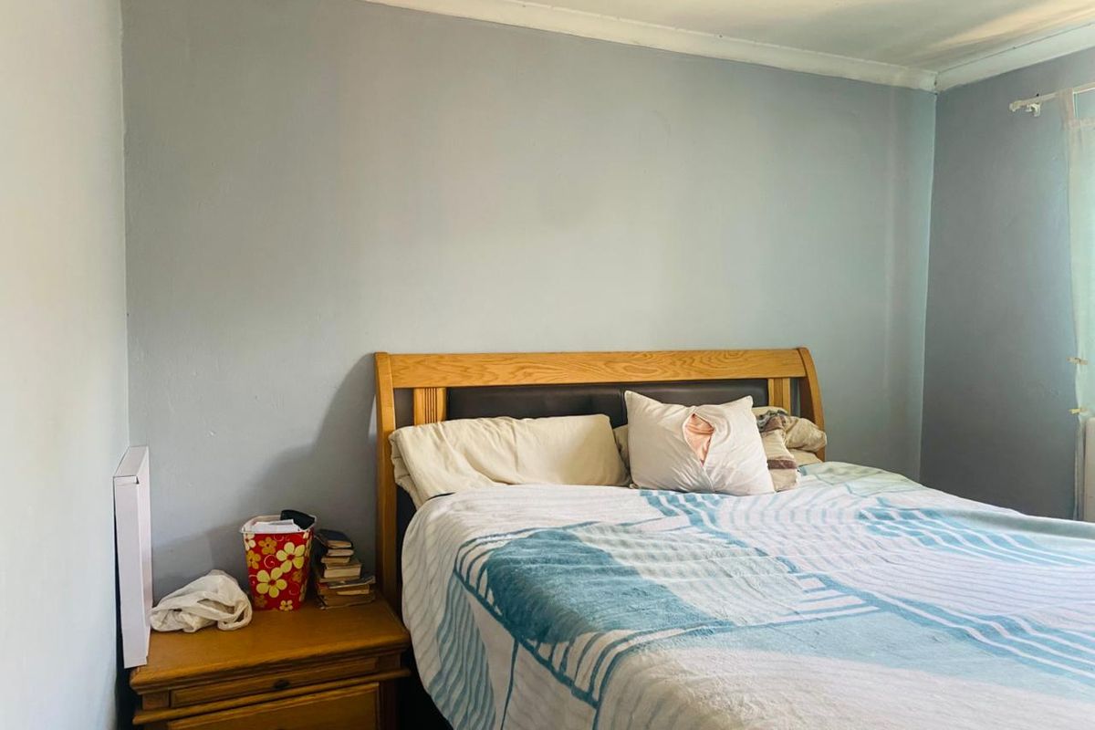 A standard bedroom featuring light blue walls and decorative ceiling coving, providing a neutral base for potential interior updates.