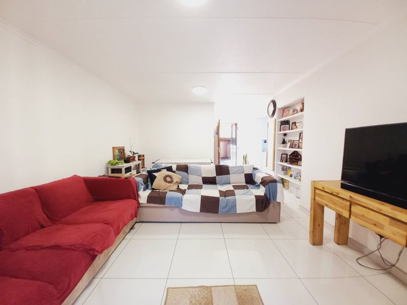 A living room featuring white tiled flooring and built-in wall shelving, providing a neutral base for interior design.