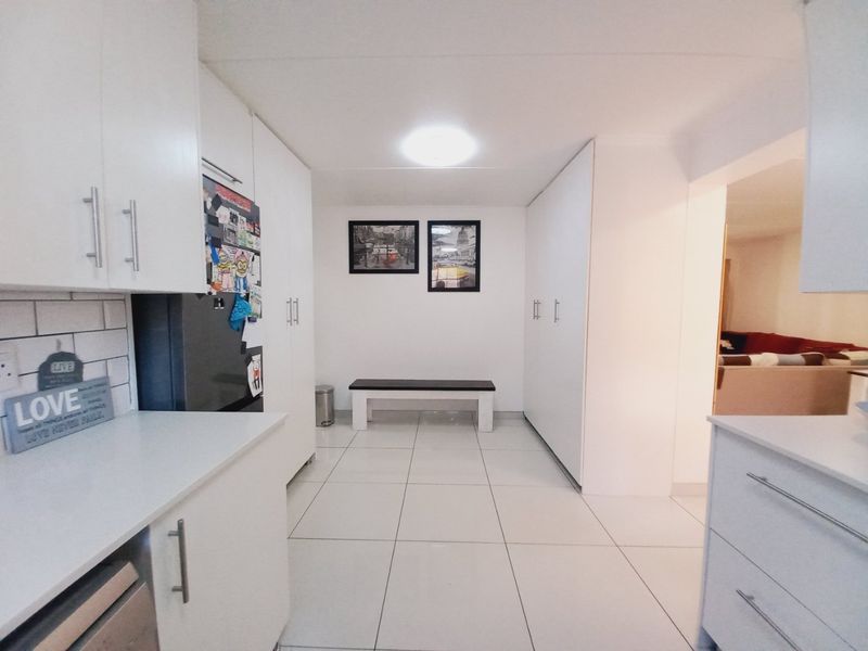 A bright, modern kitchen featuring white cabinetry, subway tile backsplash, and clean tiled flooring, offering a functional and well-maintained workspace.