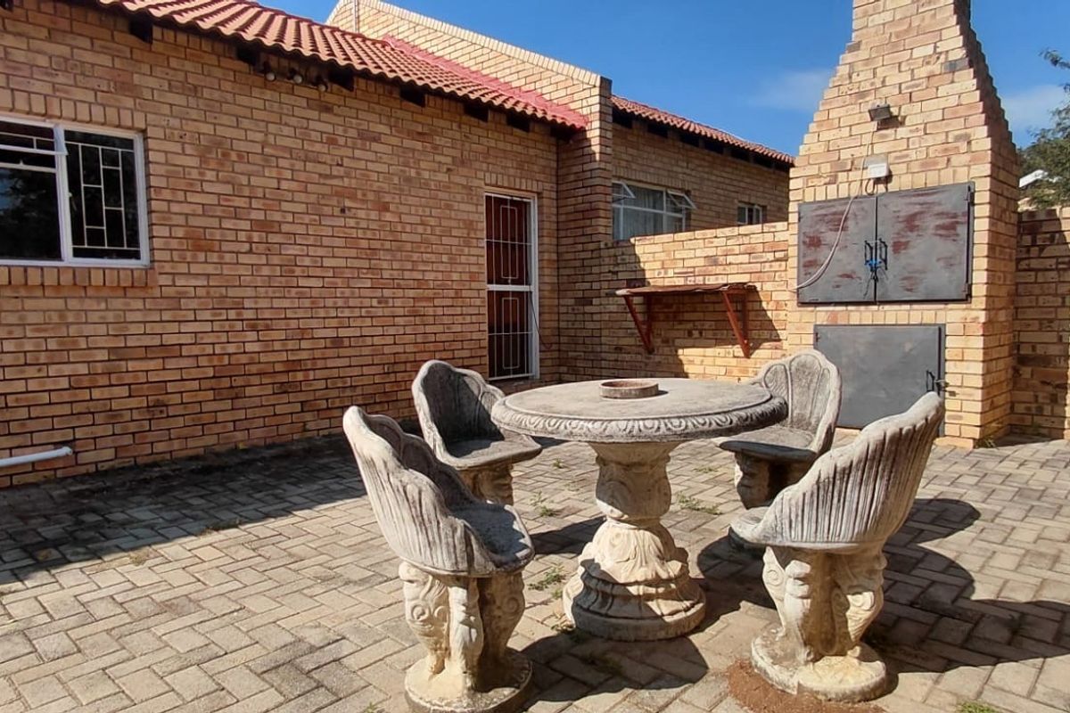 Rear patio area featuring a built-in brick braai, paved flooring, and direct access to the townhouse exterior.