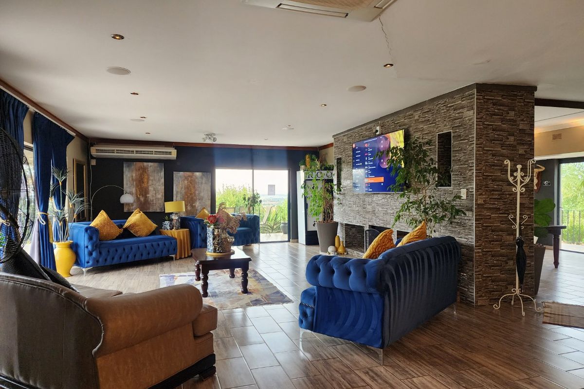 Spacious living area featuring a stone-clad feature wall, tiled flooring, and large sliding doors leading to an outdoor space.