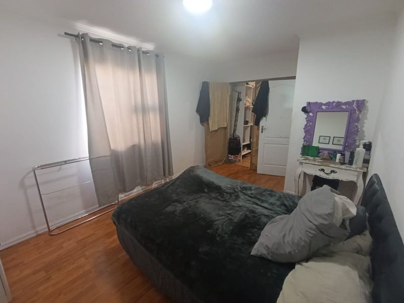 A functional bedroom featuring laminate flooring, a built-in closet, and neutral wall finishes, offering a blank canvas for potential interior updates.