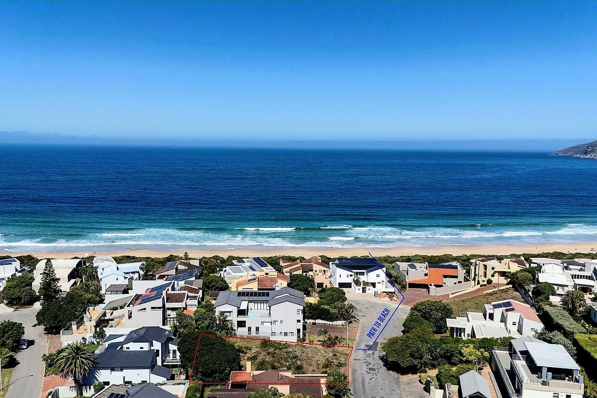 Aerial view of a residential plot situated in a prime coastal location with direct path access to the beach.