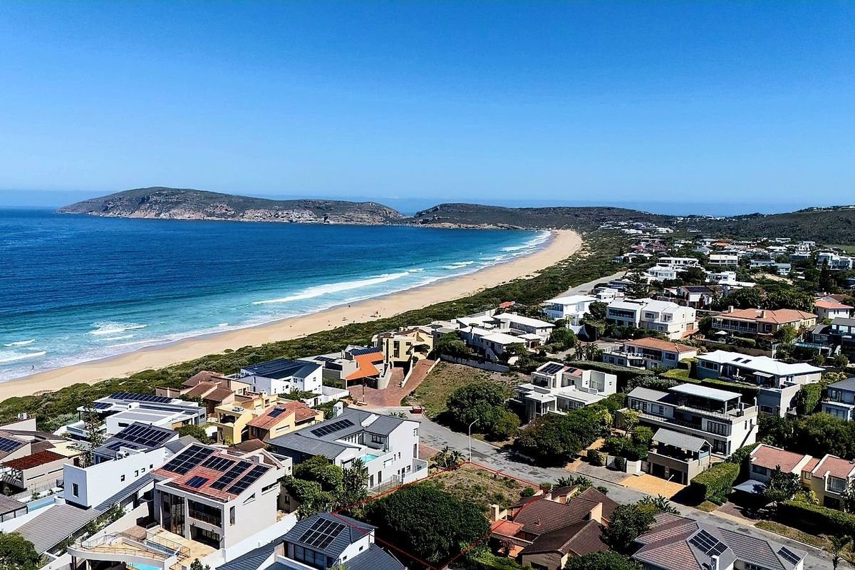 An elevated aerial view showcasing the coastal residential neighborhood, beach, and surrounding landscape.