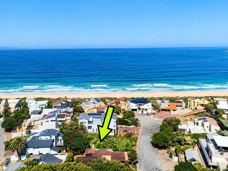 Aerial view of a vacant residential plot situated in a prime coastal location with direct proximity to the beach.