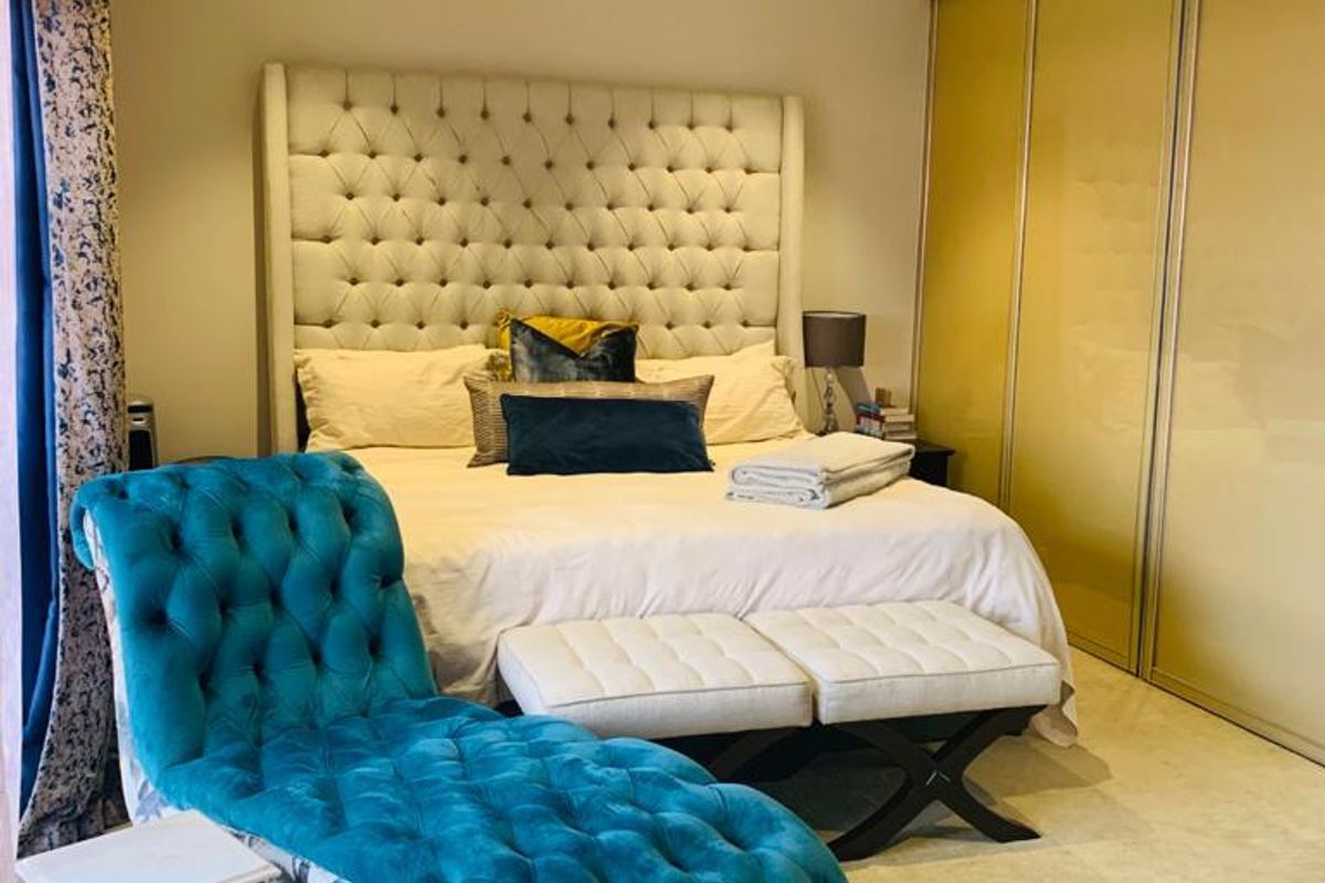 A well-maintained bedroom featuring built-in sliding door wardrobes, recessed downlighting, and neutral carpeting.