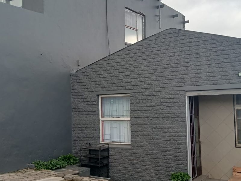 Front exterior view of the property featuring a roller garage door, brick facade, and a small covered patio entrance.