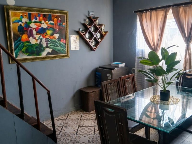 A dining area featuring patterned floor tiles and an adjacent staircase, providing a functional space for meals.