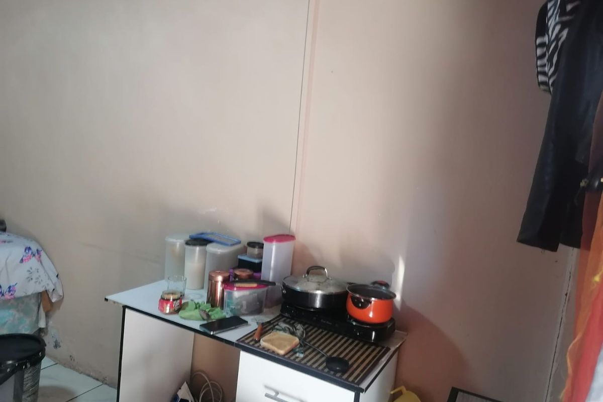 A small, basic food preparation area featuring a portable cooktop on a compact utility unit.