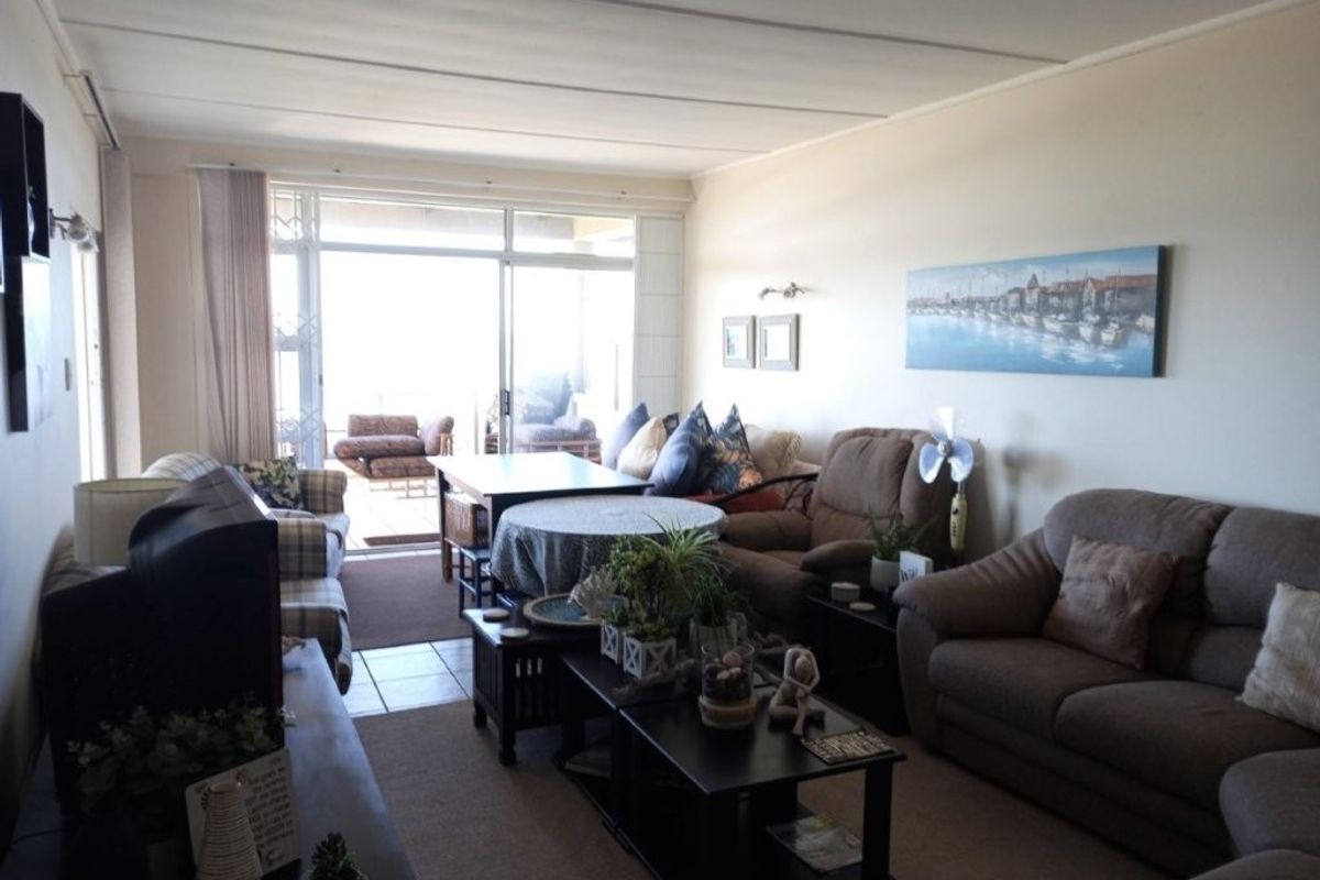 Spacious living room featuring tiled flooring and large sliding glass doors that provide access to an outdoor balcony area.