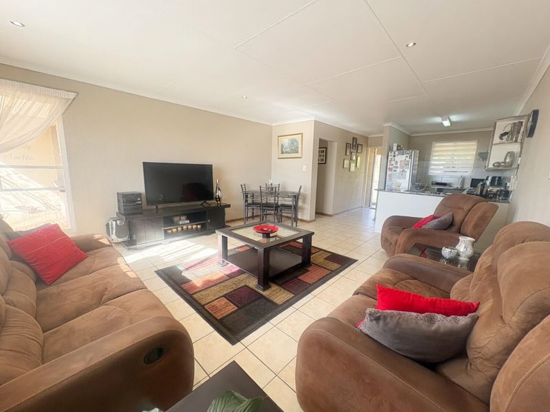 Spacious open-plan living and dining area featuring tiled flooring, recessed lighting, and a functional kitchen layout with ample counter space.