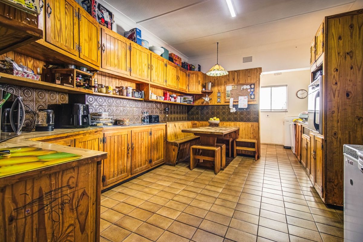 Spacious kitchen featuring extensive timber cabinetry, tiled splashbacks, and a built-in dining nook with integrated bench seating.