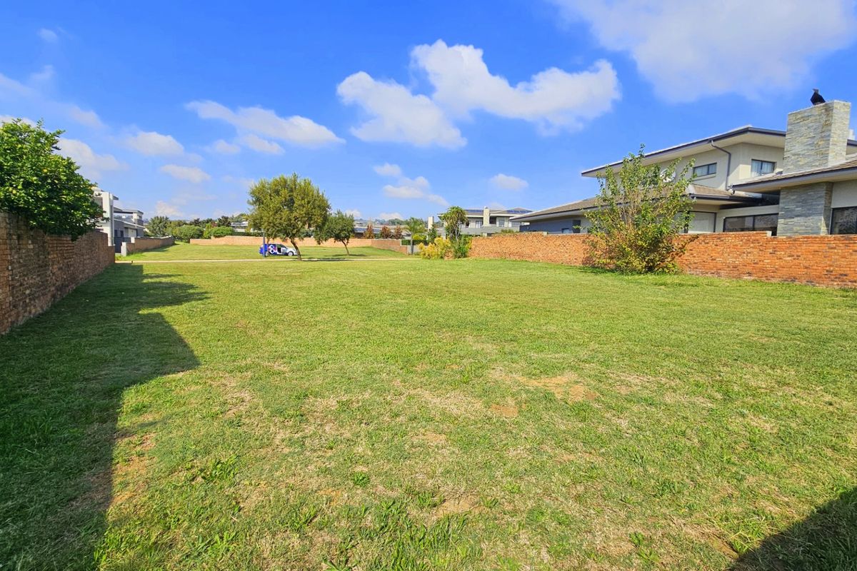 A spacious, level residential vacant plot enclosed by brick boundary walls, offering a clear building site within an established neighborhood.