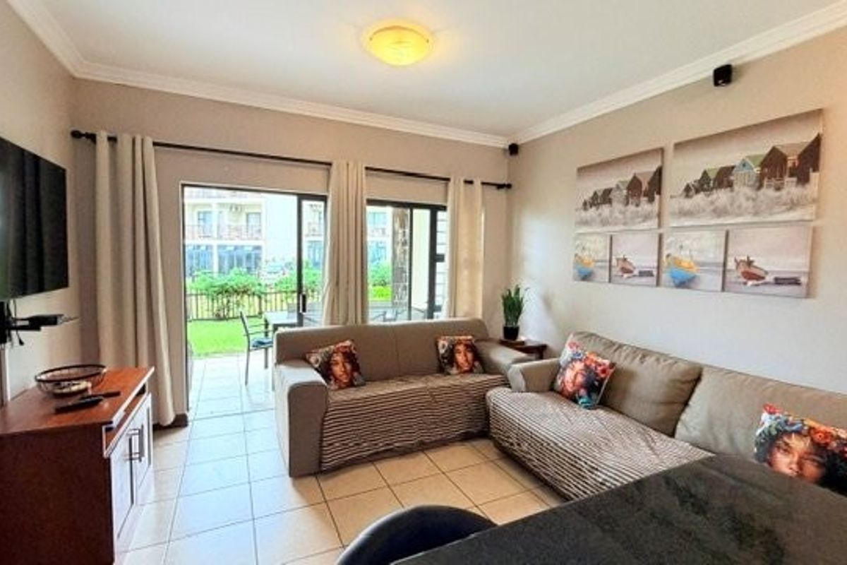 A comfortable living room featuring tiled flooring and large sliding glass doors that provide direct access to an outdoor patio area.