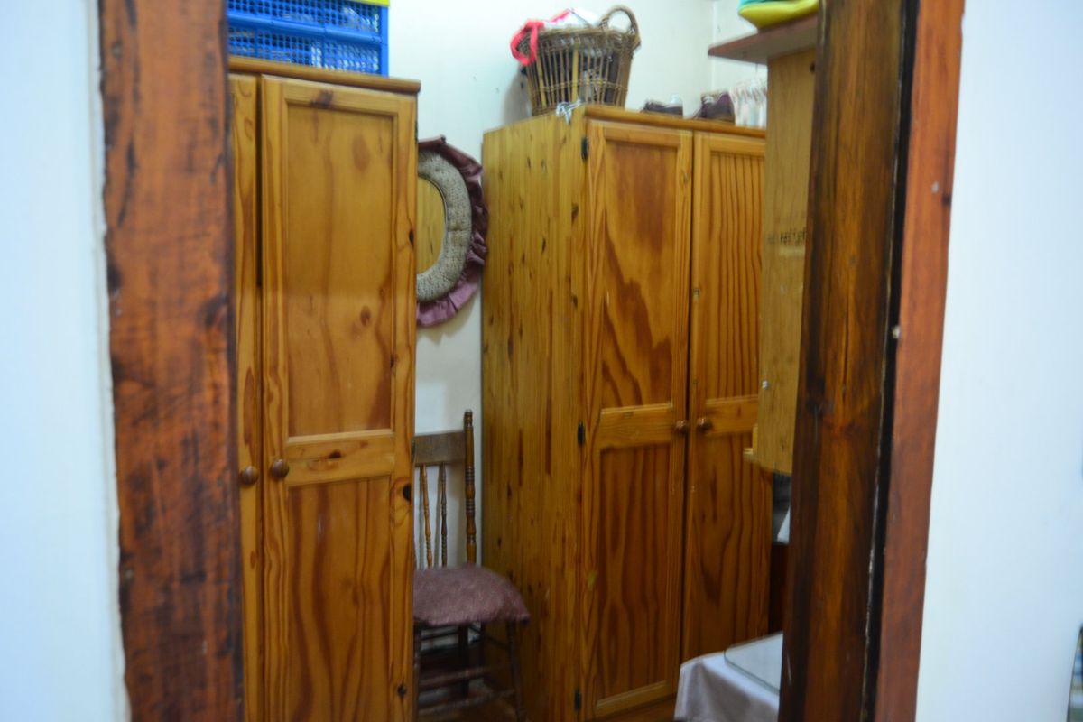 A bedroom interior featuring built-in wooden cabinetry for storage.