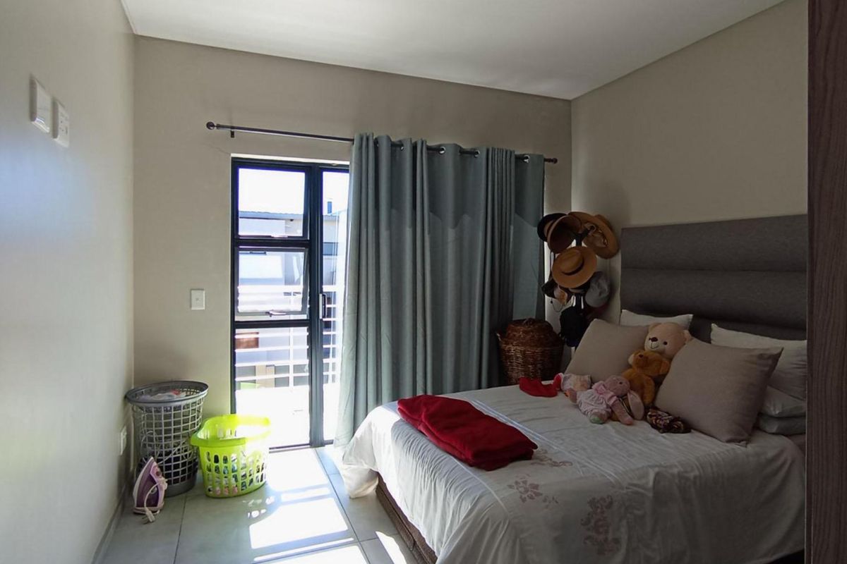 A bedroom featuring tiled flooring and a sliding glass door providing access to an outdoor area.