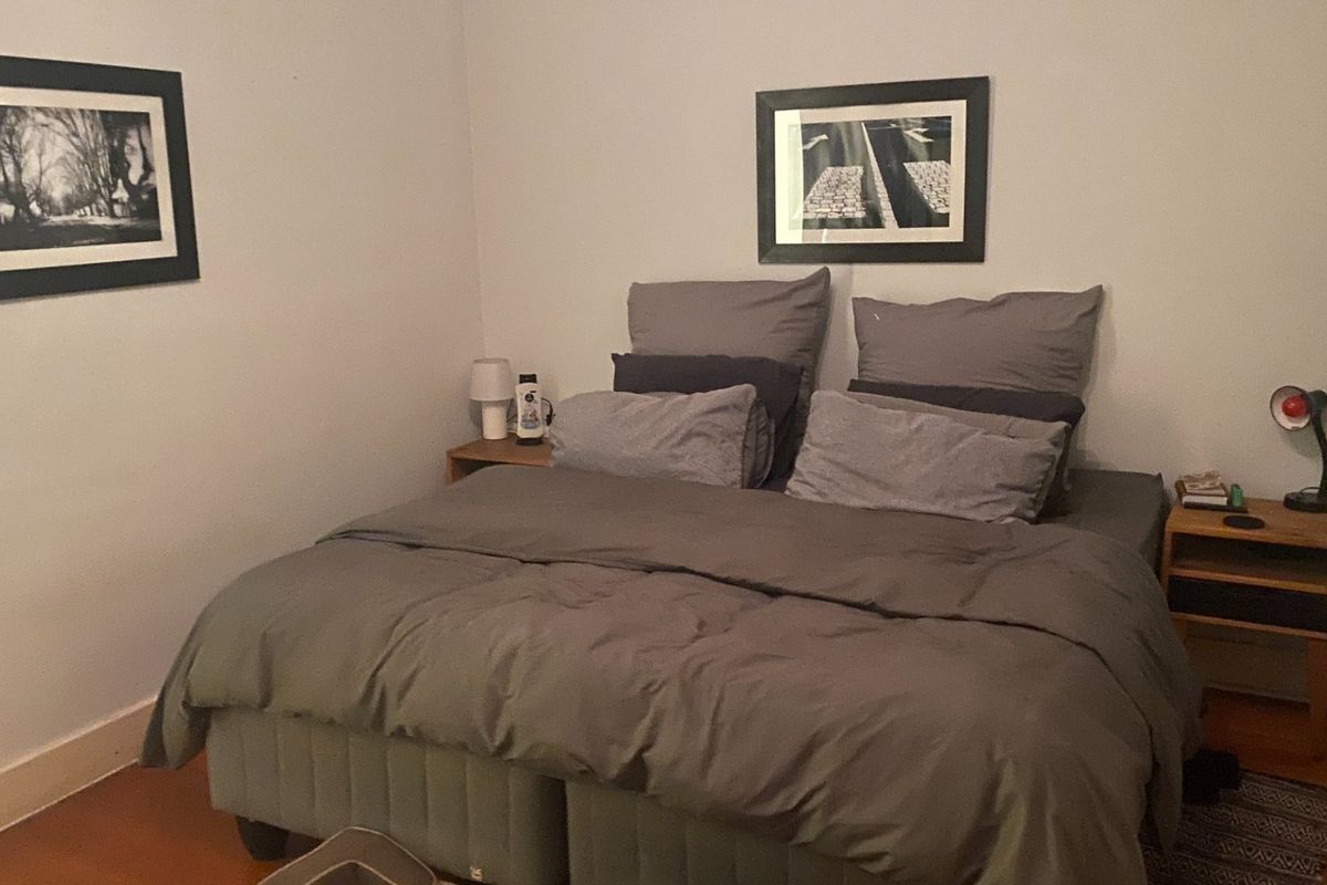 A cozy bedroom featuring hardwood flooring and neutral wall finishes, providing a comfortable and functional sleeping space.