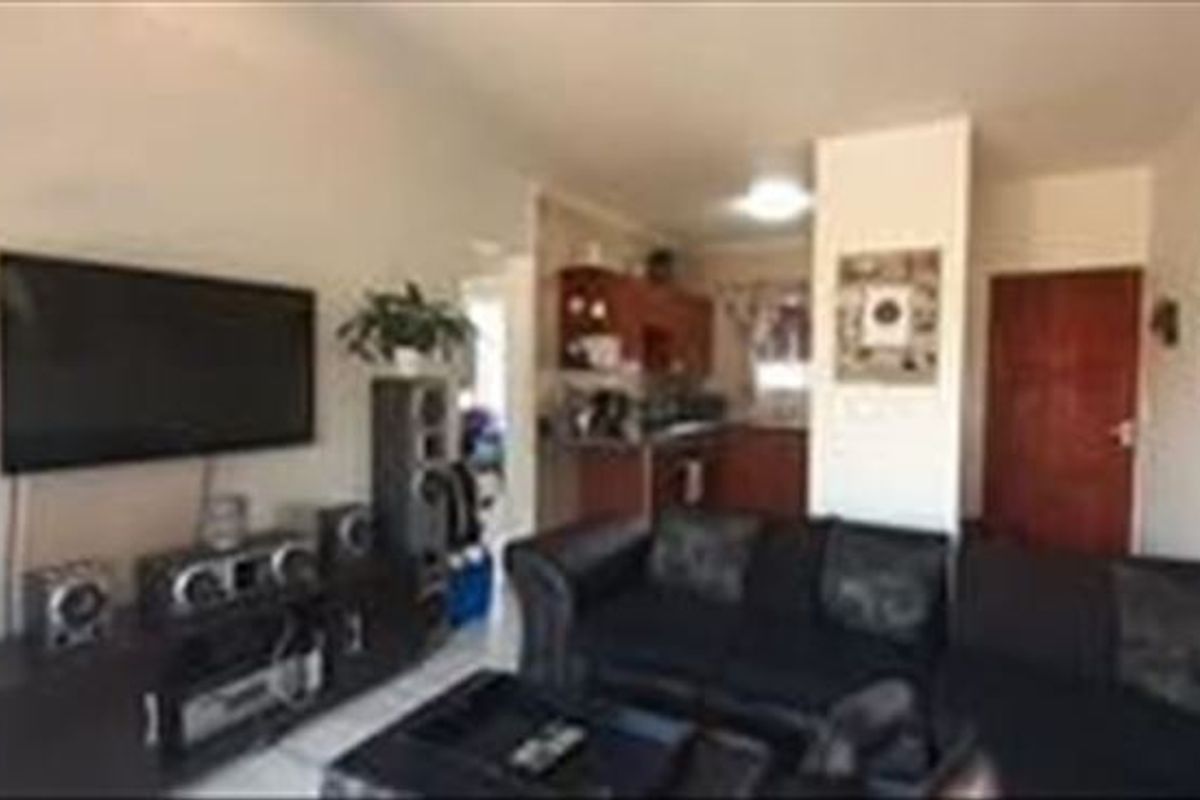 Open plan living area featuring a combined lounge space and a functional kitchen with built-in cabinetry.