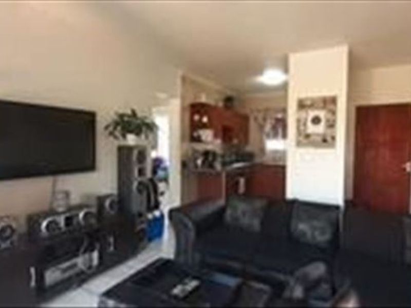 Open plan living area featuring a combined lounge space and a functional kitchen with built-in cabinetry.