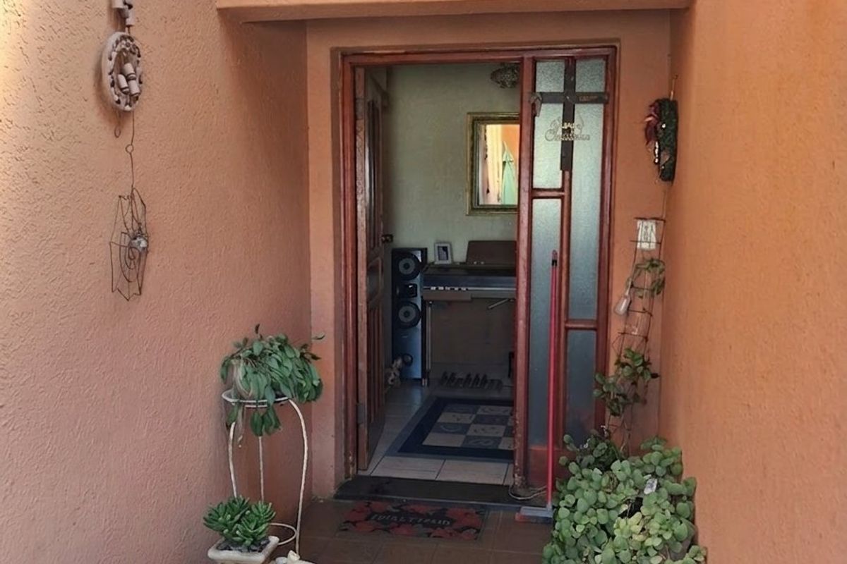 A covered entrance area featuring tiled flooring and textured walls, leading into the main interior of the home.