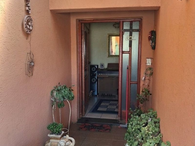A covered entrance area featuring tiled flooring and textured walls, leading into the main interior of the home.