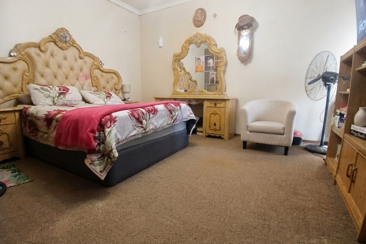 A spacious bedroom featuring carpeted flooring and decorative coving, offering a blank canvas for potential updates and modernization.