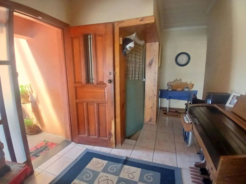 Entrance area featuring tiled flooring and a solid timber door, providing access to the interior living space.