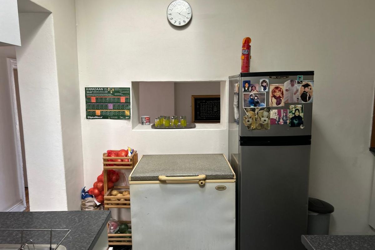 A functional kitchen area featuring a convenient pass-through window and durable laminate countertops, providing a practical layout for daily food preparation.