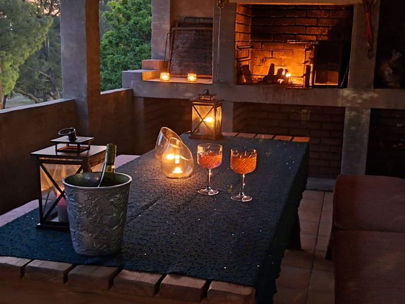 A covered patio area featuring a built-in brick braai and tiled flooring, ideal for outdoor entertaining.