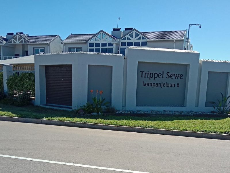 Street view of the Trippel Sewe apartment complex entrance, featuring a modern boundary wall and secure access gate.