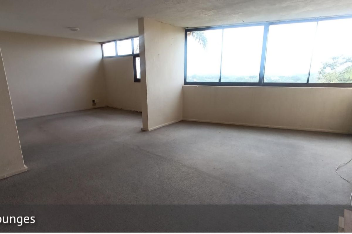 Spacious, empty living area featuring large windows that provide ample natural light and expansive views.