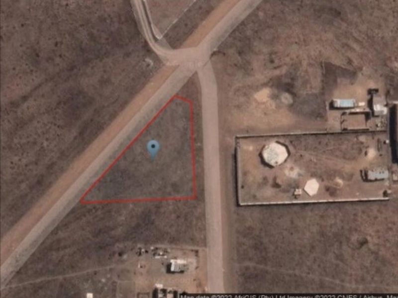 An aerial satellite view showing the vacant residential plot boundaries located at a street intersection.