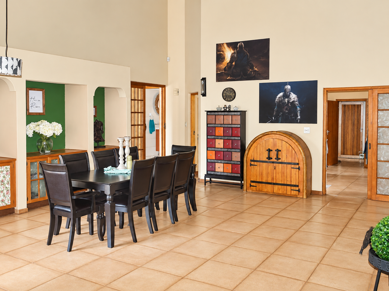 Spacious dining area featuring high ceilings, ceramic tile flooring, and unique built-in arched wall niches, providing a functional and open layout.