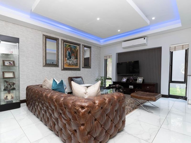 Modern living room featuring a recessed ceiling with ambient LED lighting, sleek porcelain floor tiles, and a stylish slatted timber feature wall.