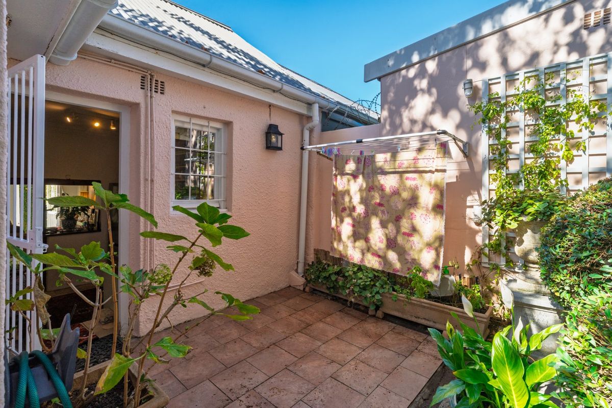 A private rear courtyard featuring tiled flooring, a wall-mounted clothesline, and a trellis, providing a functional outdoor space accessible from the main dwelling.