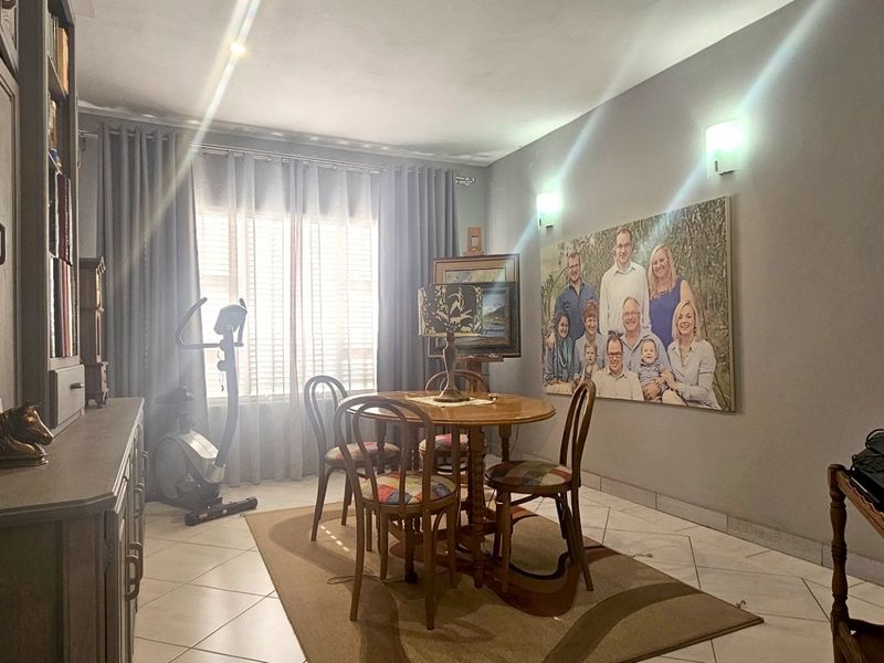 A dining room featuring tiled flooring, built-in cabinetry, and wall-mounted lighting fixtures, offering a functional space for meals.