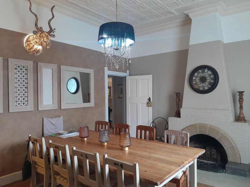A dining room featuring a traditional fireplace, decorative pressed metal ceiling, and classic architectural detailing.