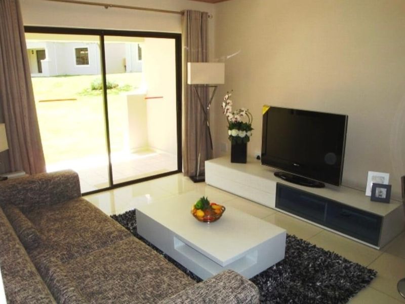 A well-lit living room featuring large sliding glass doors that provide direct access to the outdoor patio area.