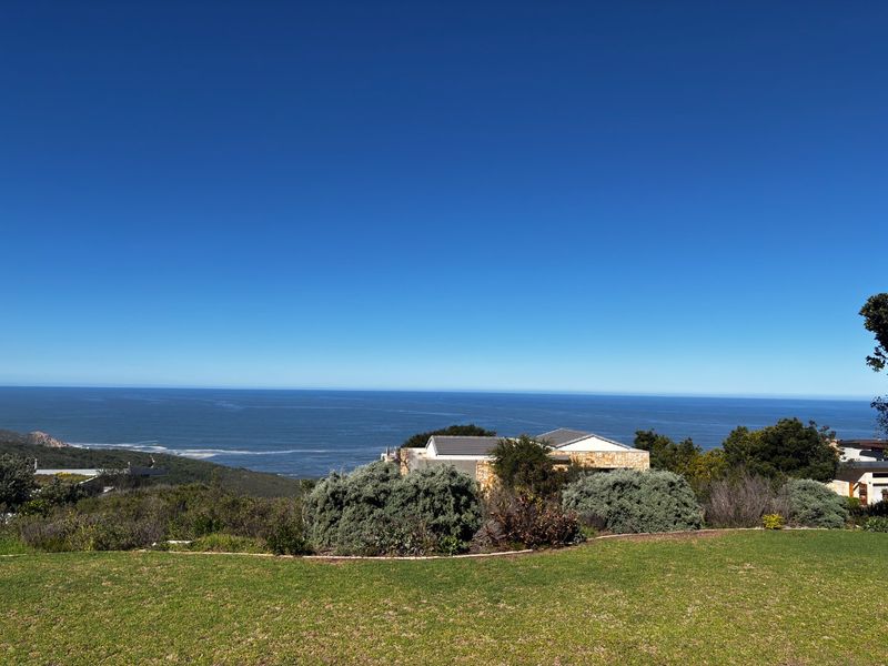 A scenic elevated view overlooking the ocean and surrounding coastal landscape from a well-maintained grassy area.