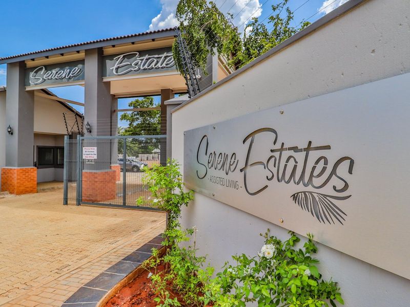 The main entrance to Serene Estates, featuring a secure gated access point, paved driveway, and professional estate signage.