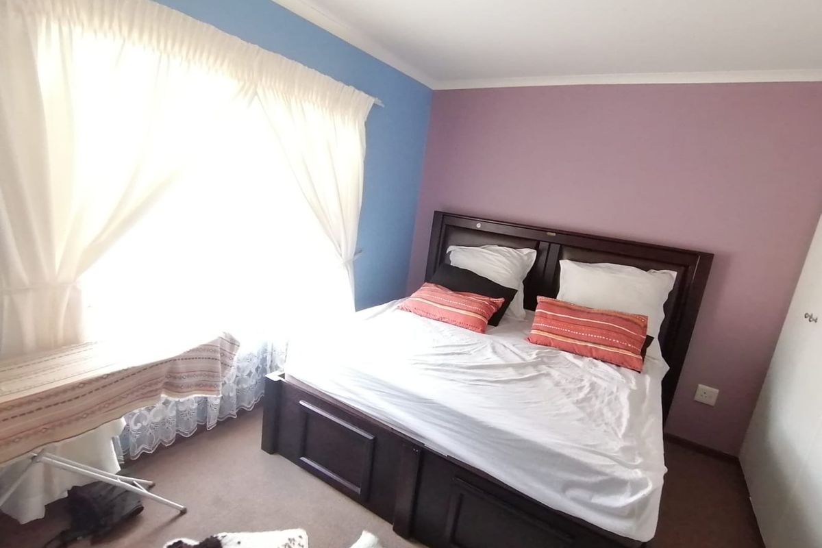 A bedroom featuring carpeted flooring and dual-tone painted walls, providing a functional space for rest.