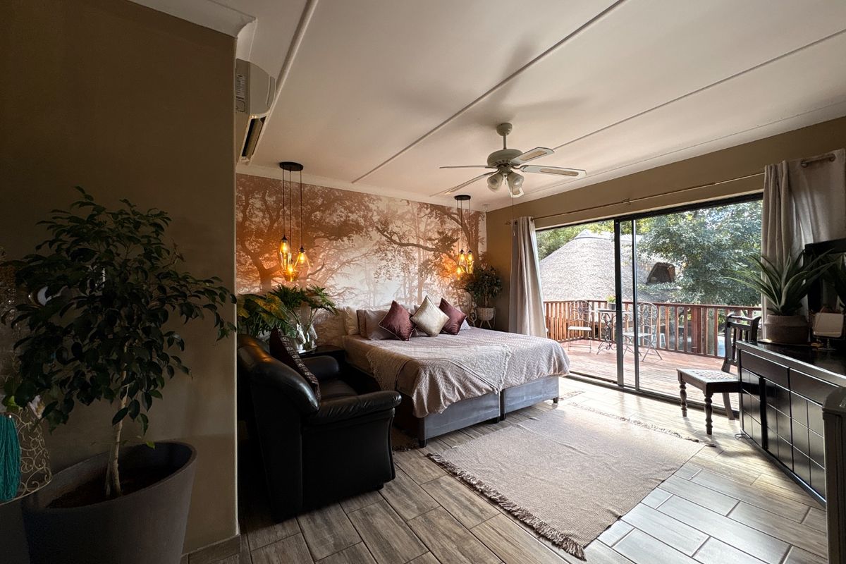 Spacious bedroom featuring tiled flooring, a ceiling fan, air conditioning, and large sliding glass doors opening onto a private balcony.