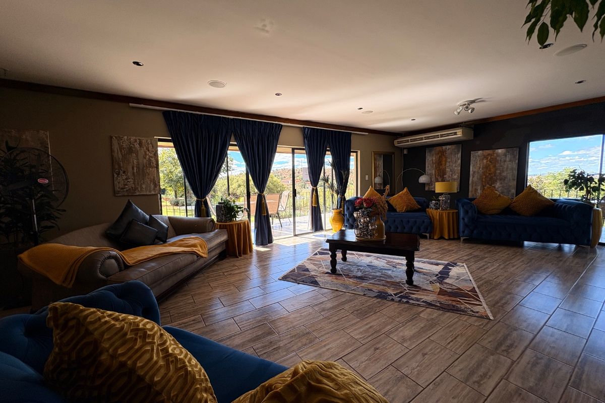 Spacious living room featuring wood-look tile flooring, recessed lighting, and large sliding glass doors providing natural light and access to the outdoor area.