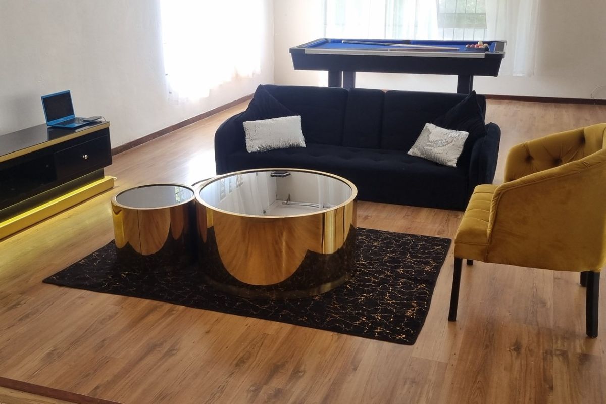 Spacious living area featuring wood-look laminate flooring and large windows, providing a bright and open atmosphere.